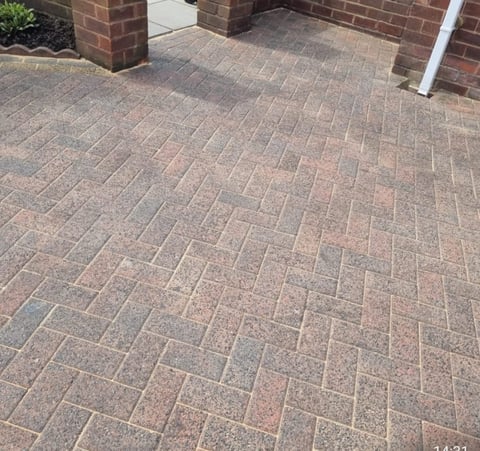 Herringbone pattern paved driveway made of red and brown pavers